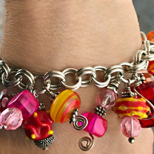 This Suzie Q Studio charm bracelet is perfect for anyone who adores color and loves to make a statement. The sterling silver chain is handcrafted and each of the glass bead-charms are embellished with sterling silver accents for a whimsically happy, one-of-a-kind bracelet.