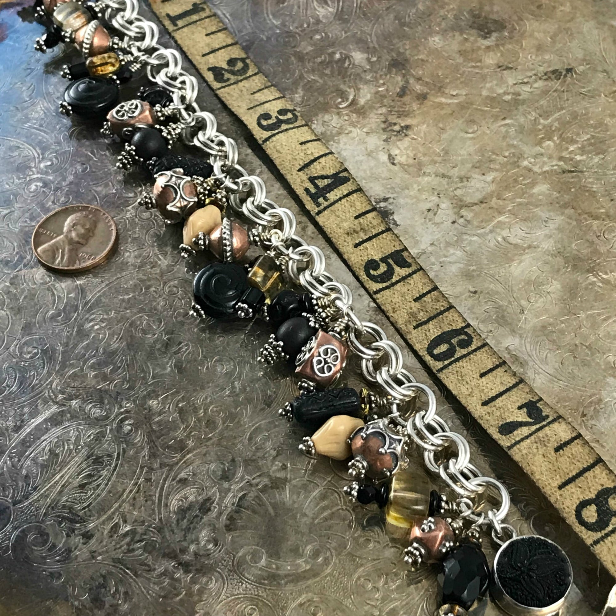 Available at Suzie Q Studio -- Czech glass, copper, sterling bead charm bracelet. The neutral colored bead-charms featured on this handcrafted sterling silver charm bracelet will go with a wide variety of styles and colors of outfits in your wardrobe. 