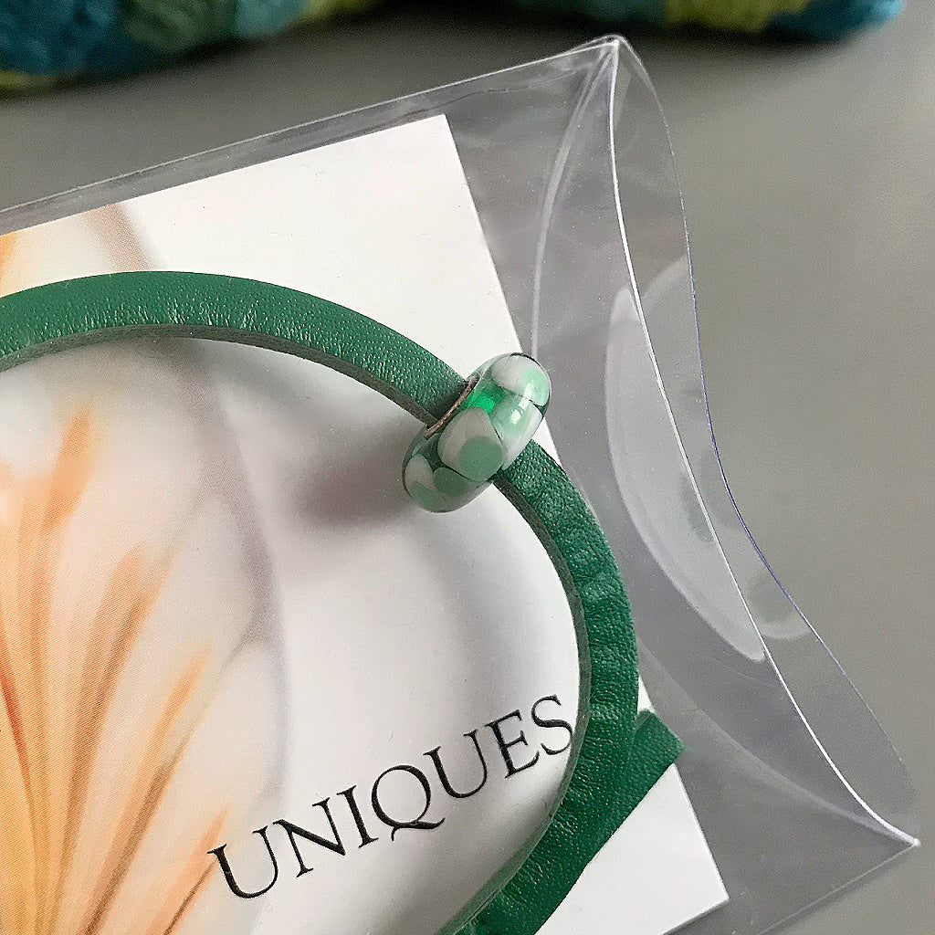 Trollbeads UNIQUES are one-of-a-kind glass beads handmade individually by 100% artisan-owned workshops. The minty green “flower petal” design in this Suzie Q Studio UNIQUES glass bead reminds you of a lush spring garden.