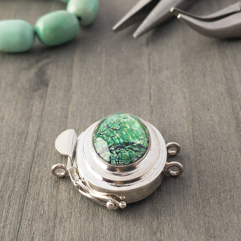The metallic-effect of the vintage glass cabochon stone in this double strand, sterling silver box clasp is called a  "harlequin" finish, which is extremely popular, and this blue-green version is exquisite!