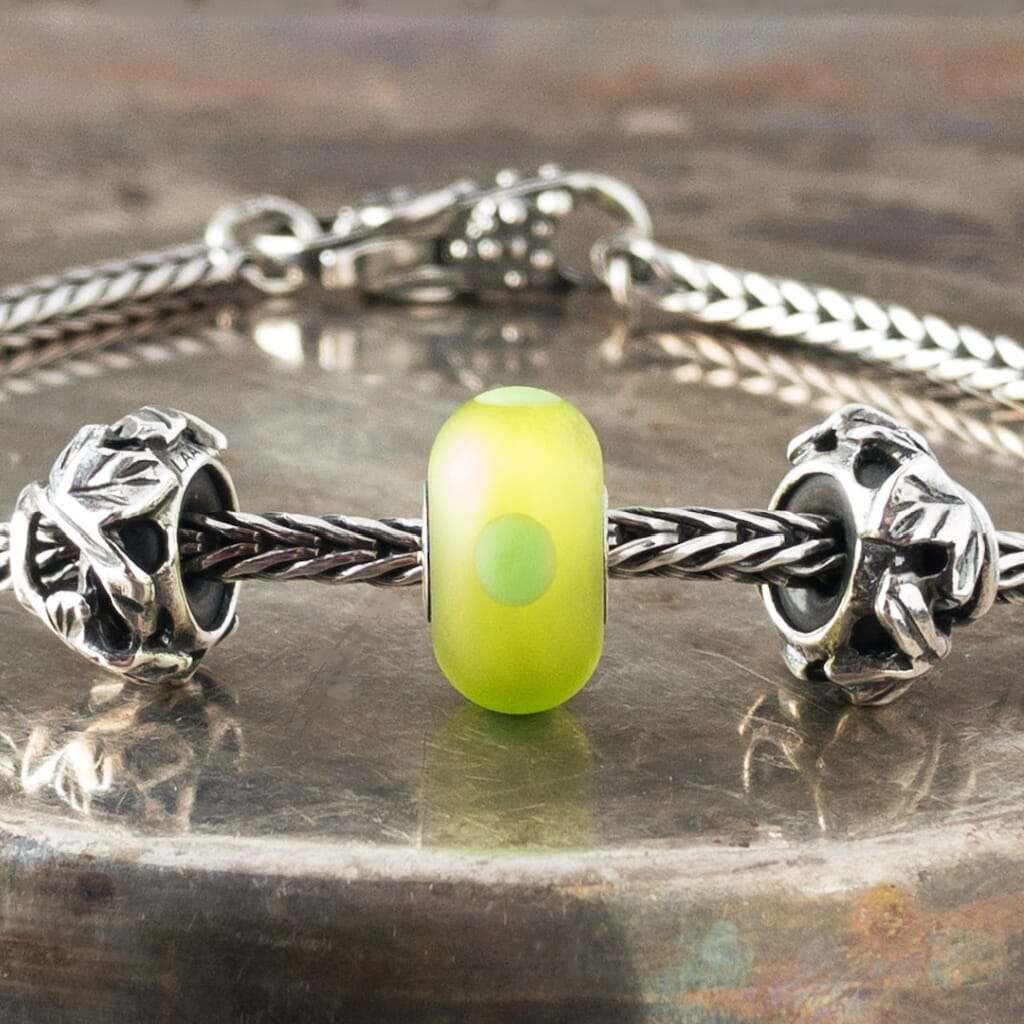 The sandblasted surface of Suzie Q Studio's Green Sand Trollbead absorbs and softens the light in this brightly-coloured bead giving it a luscious inner glow. Visit Suzie Q Studio for new stock, never worn, collectible Rare & Retired Trollbeads.
