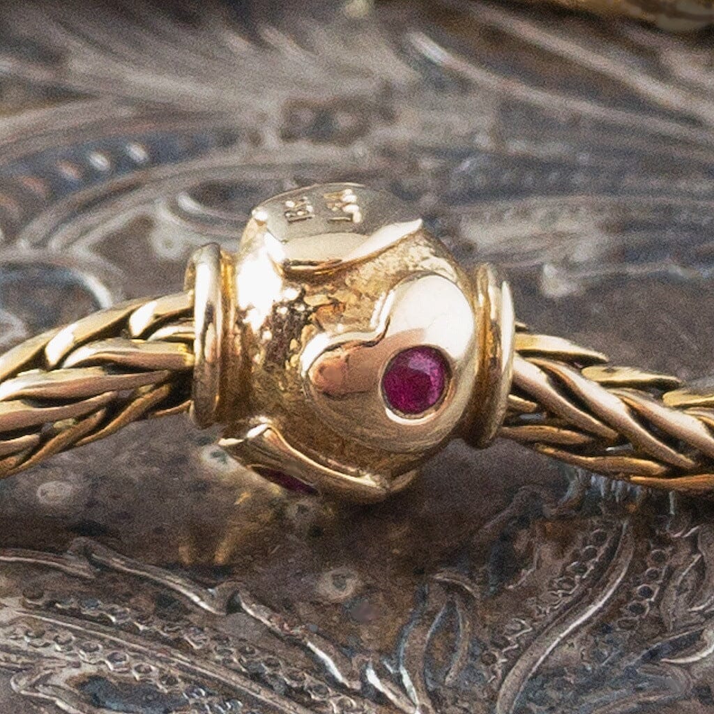 Limited Edition, 18-Karat Gold "heartbeat" Trollbead with four beautiful rubies, worn on an 18KT gold Trollbeads bracelet.