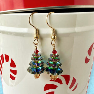 Sparkly Swarovski crystal Christmas tree earrings at Suzie Q Studio, variegated green in colour, with a red tree topper bead and gold-tone ear wires.