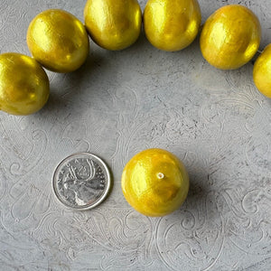 24mm round, chartreuse-coloured cotton pearl bead with beautiful pearlized finish and lightweight design, shown next to a Canadian quarter for scale, available from Suzie Q Studio.