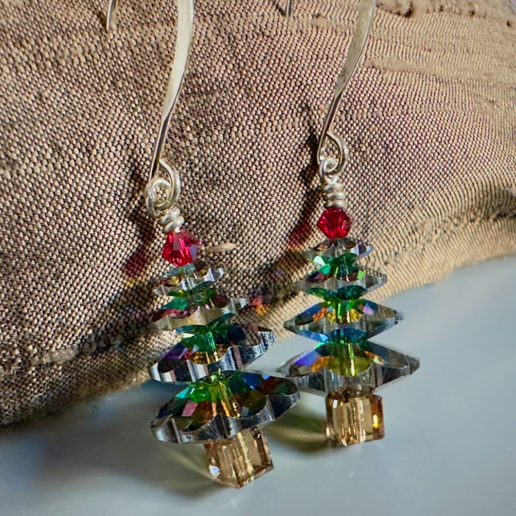 Sparkly Swarovski crystal Christmas tree earrings at Suzie Q Studio, variegated green in colour, with a red tree topper bead and silver plate ear wires.
