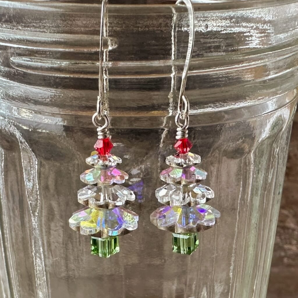 Sparkly Swarovski crystal Christmas tree earrings at Suzie Q Studio, silver foil-backed, clear crystal, with red tree top bead and silver plate ear wires.