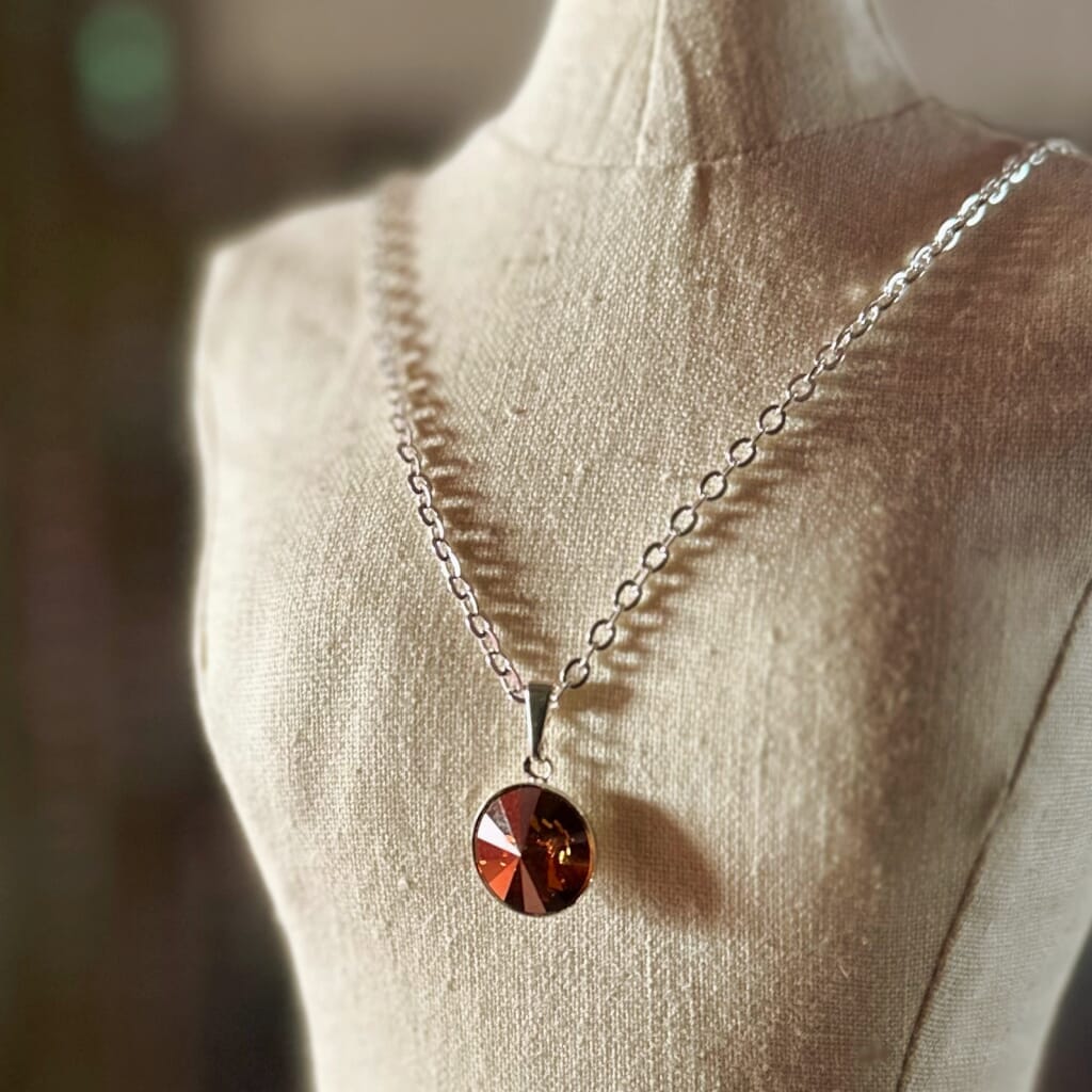 Swarovski crystal necklace, with round, "rivoli” stone pendant, with a crystal "copper" finish, on a delicate, silver-plated chain.