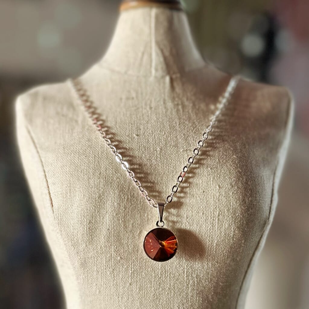 Swarovski crystal necklace, with round, "rivoli” stone pendant, with a crystal "copper" finish, on a delicate, silver-plated chain.
