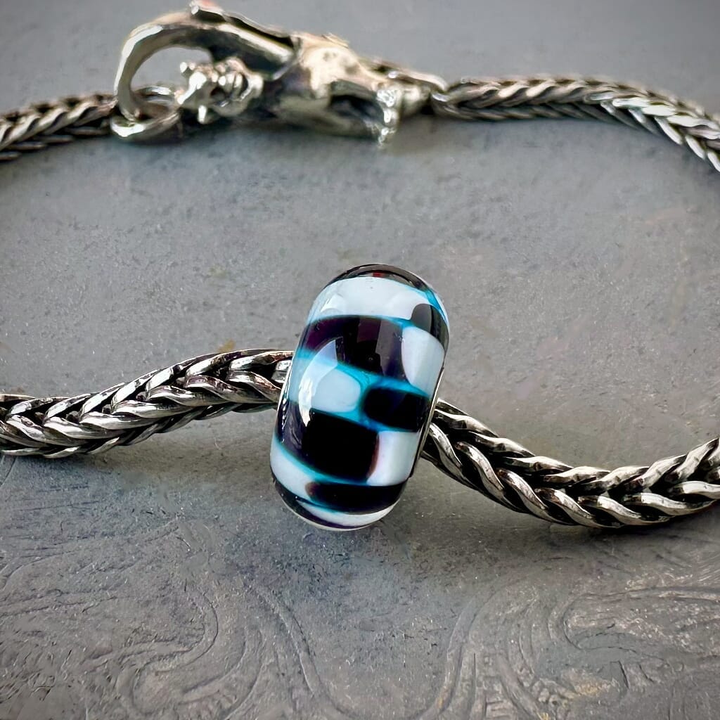 Trollbeads 30th Anniversary, blue, black and white glass bead called, TROLL SHADES, originally released in 2006, shown on a sterling silver bracelet, with lock. Shop online for one-of-a-kind treasures at Suzie Q Studio.
