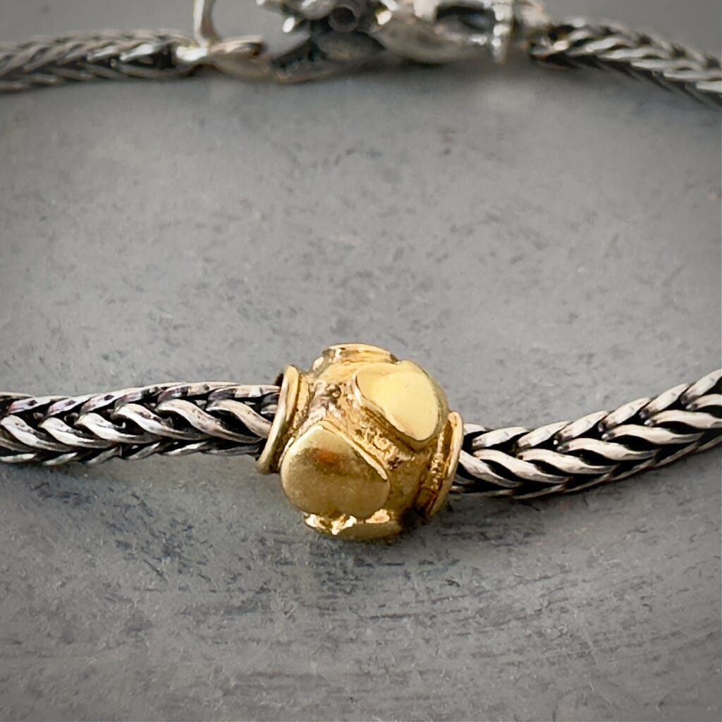 Trollbeads 30th Anniversary, 18KT gold bead called, HEARTBEATS, originally released in 2006, shown on a sterling silver bracelet, with lock. Shop online for one-of-a-kind treasures at Suzie Q Studio.