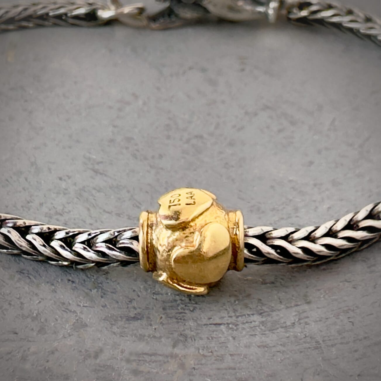 Trollbeads 30th Anniversary, 18KT gold bead called, HEARTBEATS, originally released in 2006, shown on a sterling silver bracelet, with lock.