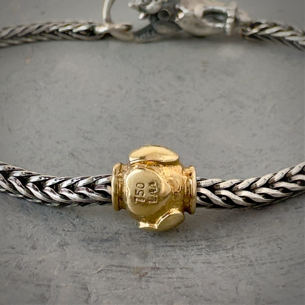 Trollbeads 30th Anniversary, 18KT gold bead called, HEARTBEATS, originally released in 2006, shown on a sterling silver bracelet, with lock.