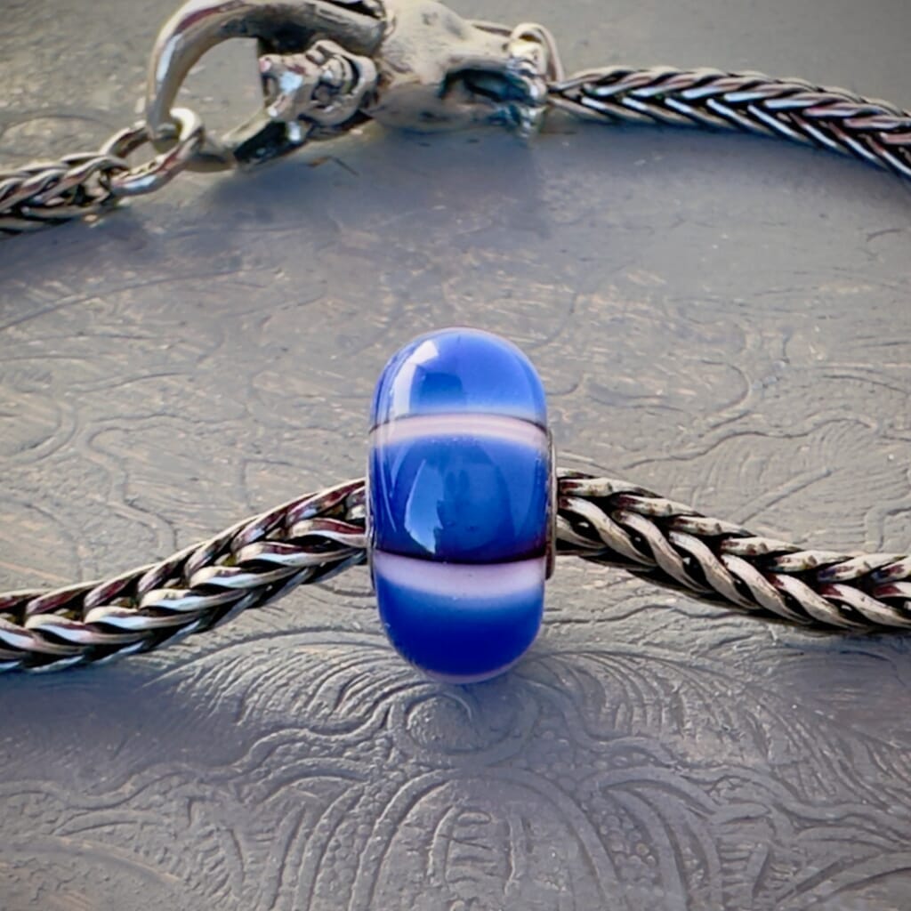 LE Trollbeads 30th Anniversary, glass bead, in white and various tones of blue, called, STRIPE OF THE SEA, shown on a sterling silver bracelet, with lock. Shop online for one-of-a-kind treasures at Suzie Q Studio.