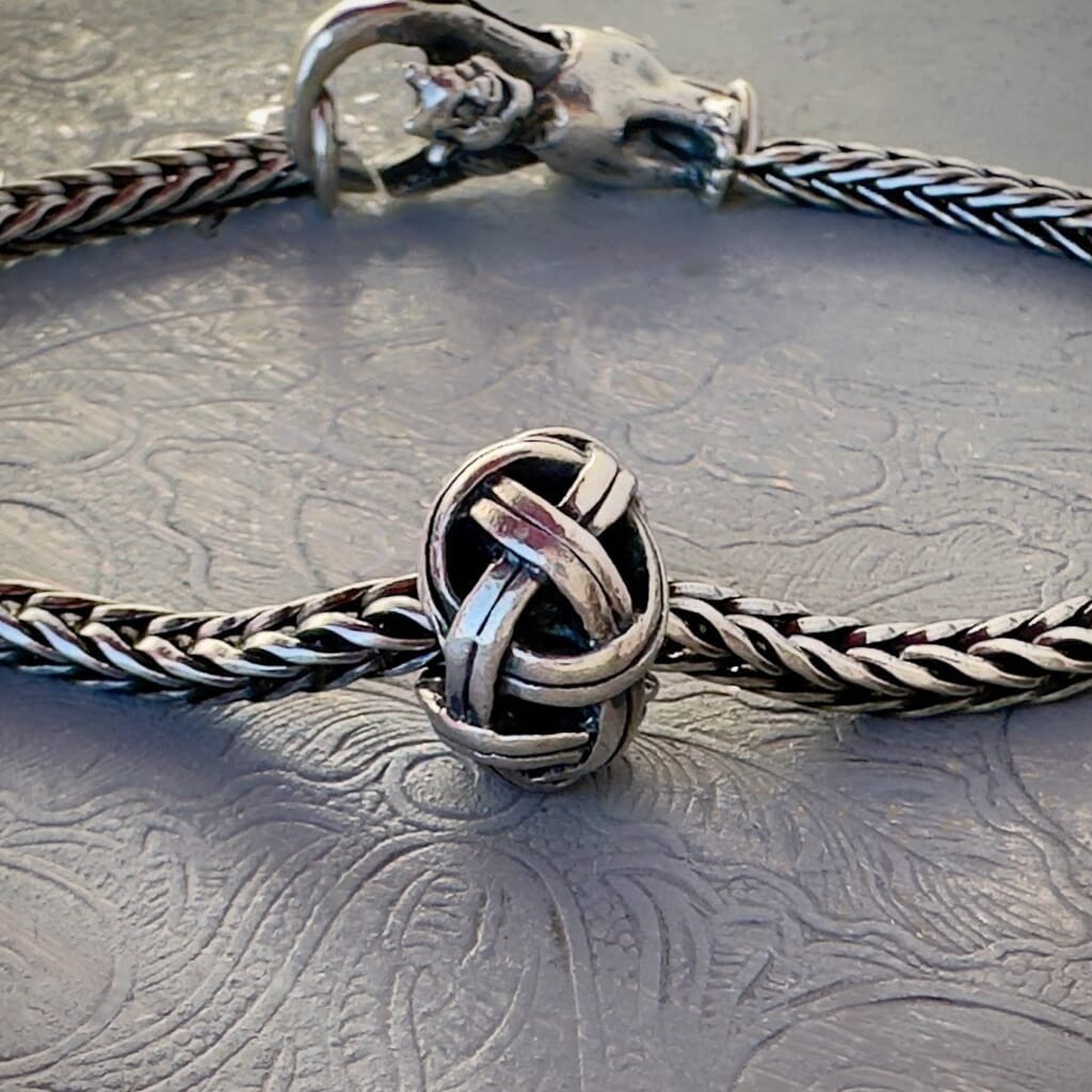 Trollbeads 30th Anniversary, sterling silver bead called, VIKING KNOT, originally released in 2006, shown on a sterling silver bracelet, with lock. Visit Suzie Q Studio for new stock, never worn, collectible Rare & Retired Trollbeads.