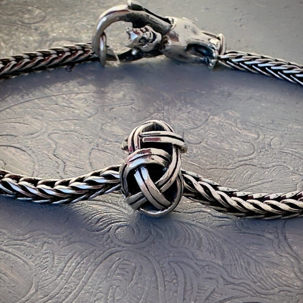 Trollbeads 30th Anniversary, sterling silver bead called, VIKING KNOT, originally released in 2006, shown on a sterling silver bracelet, with lock. Visit Suzie Q Studio for new stock, never worn, collectible Rare & Retired Trollbeads.