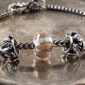 Suzie Q Studio's shimmering, faceted glass BRILLIANT DAYLIGHT SPHERE Faceted glass Trollbead is grey with sparkling copper inside. It reminds you to celebrate the daylight and stay warm when it's cold.  Suzie Q Studio has a treasure vault full of new stock, never worn Rare & Retired Trollbeads.