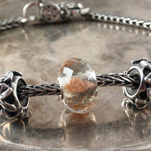 Suzie Q Studio's shimmering, faceted glass BRILLIANT DAYLIGHT SPHERE Faceted glass Trollbead is grey with sparkling copper inside. It reminds you to celebrate the daylight and stay warm when it's cold.  Visit Suzie Q Studio for new stock, never worn, collectible Rare & Retired Trollbeads.