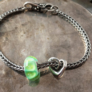 A gorgeous green glass bead with sparkling bubbles, an elegant, sterling silver heart bead and beautiful lock, all were never available individually in the Trollbeads Collection, and a classic Trollbeads foxtail-chain bracelet. Visit Suzie Q Studio for new stock, never worn, collectible Rare & Retired Trollbeads.