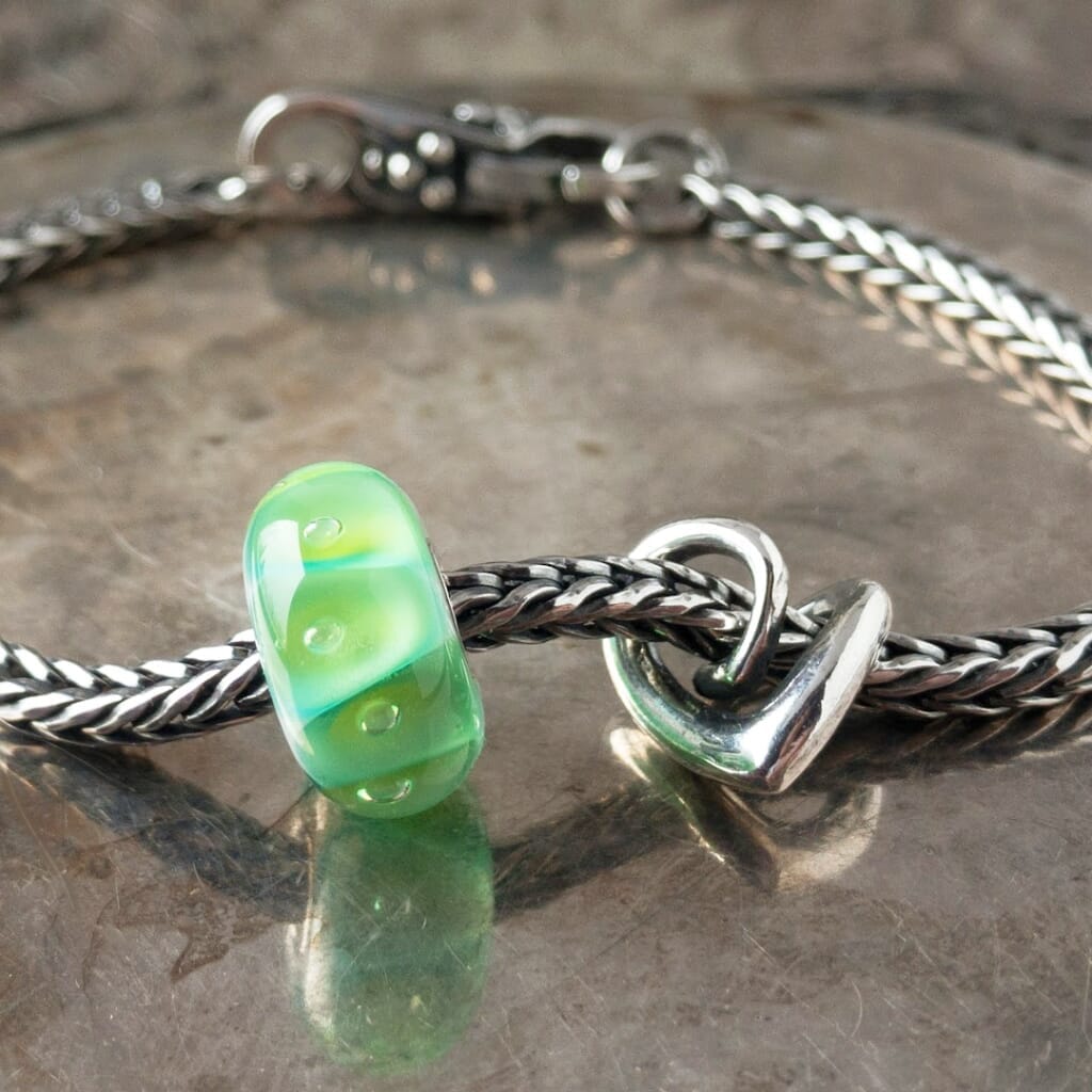 A gorgeous green glass bead with sparkling bubbles, an elegant, sterling silver heart bead and beautiful lock, all were never available individually in the Trollbeads Collection, and a classic Trollbeads foxtail-chain bracelet. Visit Suzie Q Studio for new stock, never worn, collectible Rare & Retired Trollbeads.