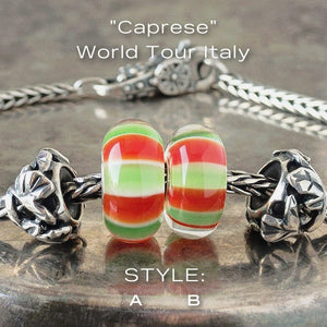 Two versions of glass Caprese Trollbead, with alternating stripes of green, white and red, on a Trollbeads silver bracelet.