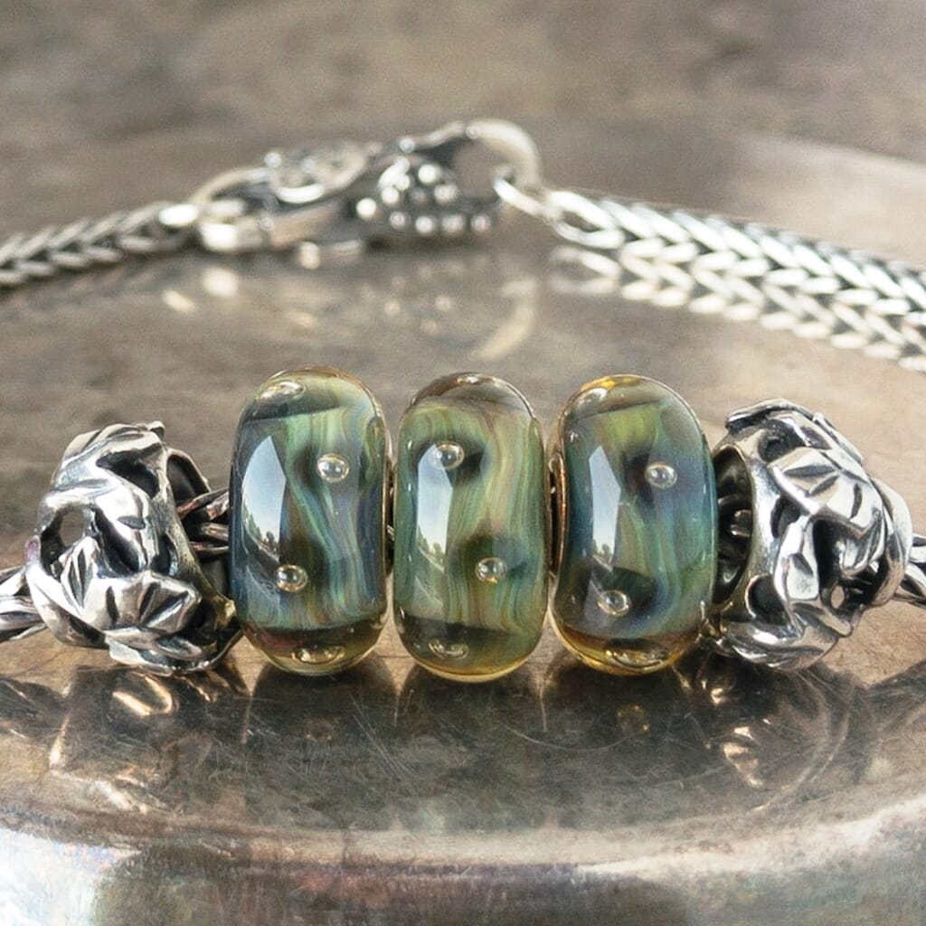 Three versions of glass ORGANIC BUBBLES Trollbead, with bubbles & organic, natural colors, on a Trollbeads silver bracelet.