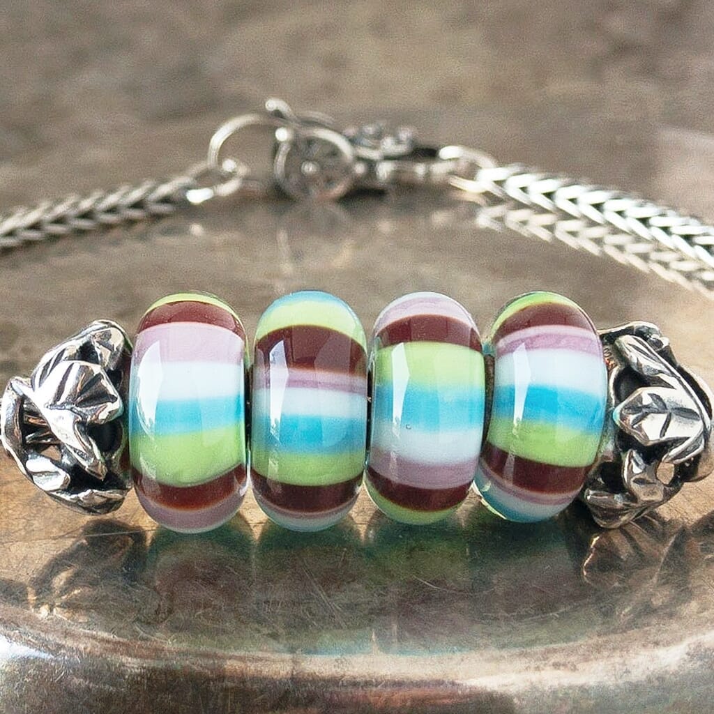 4 versions of Trollbeads STRIPE OF FASHION glass bead, with 4 colors of horizontal stripes, on a Trollbeads silver bracelet.