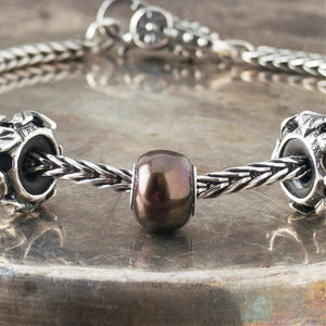 The three Black Pearl Trollbeads currently available at Suzie Q Studio have a sterling silver core and are smaller, more organically shaped than Trollbeads pearls available in later years makes them extra-unique and oh-so-precious! Visit Suzie Q Studio for new stock, never worn, collectible Rare & Retired Trollbeads.