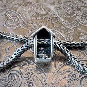 Trollbeads, retired, sterling silver, BIRDHOUSE bead, showing the inner, back side, on a sterling silver Trollbeads bracelet, on an embossed background, available at Suzie Q Studio dot com.