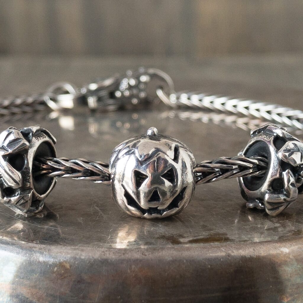 Trollbeads sterling silver PUMPKIN bead, with carved, smiling face, shown on a Trollbeads silver bracelet.