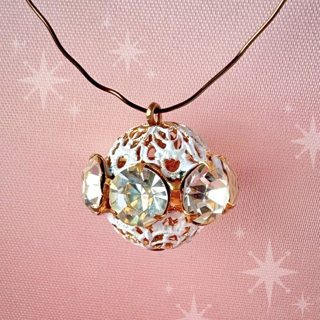 Vintage, crystal-coloured, Swarovski rhinestone bead ball on a pink background.