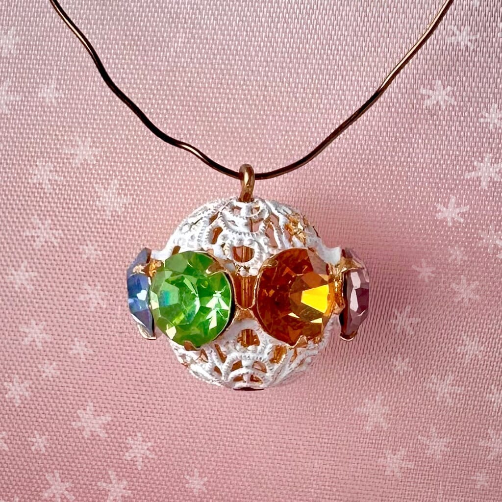 Vintage, multi-coloured, Swarovski rhinestone bead ball on pink background.