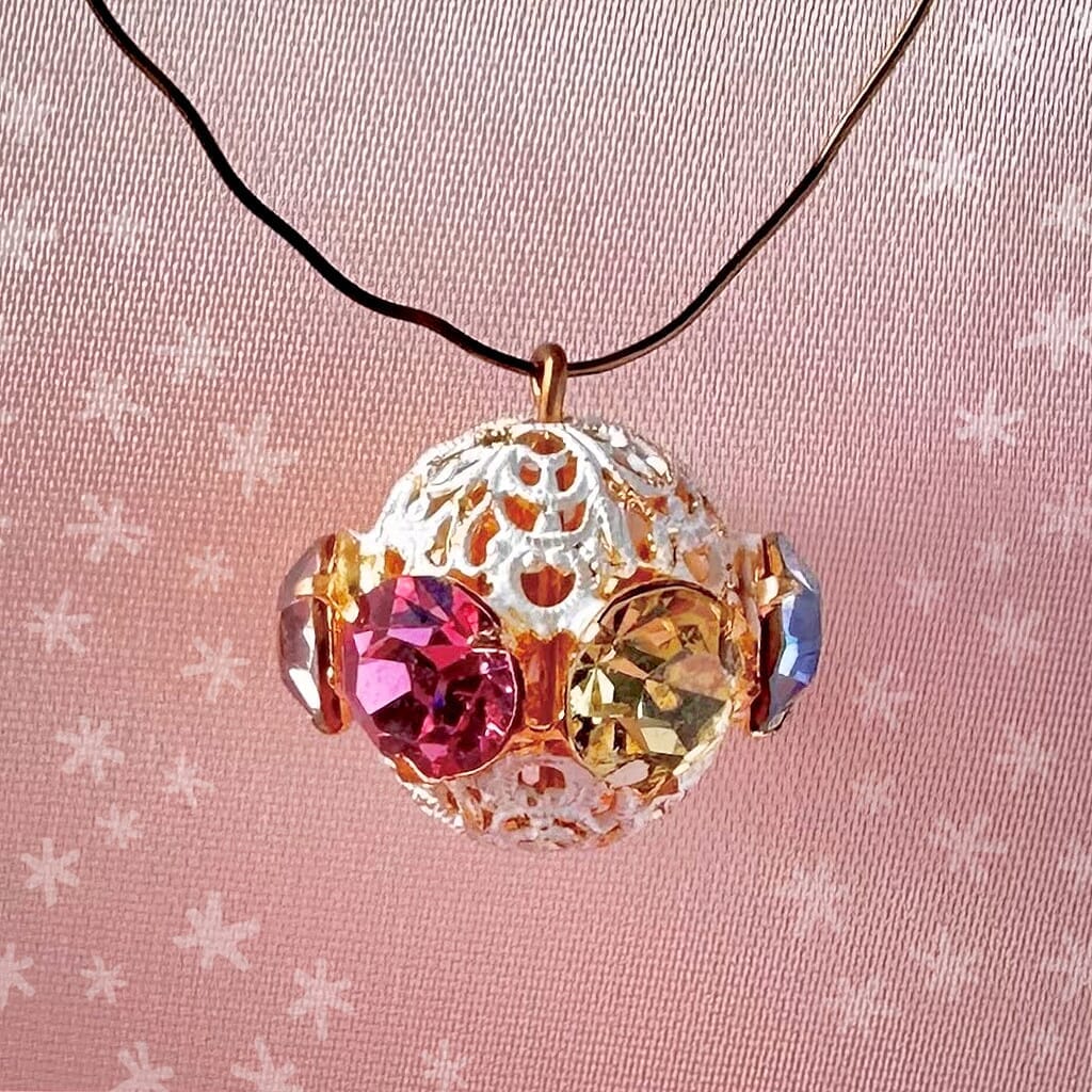 Vintage, multi-coloured, Swarovski rhinestone bead ball on pink background.