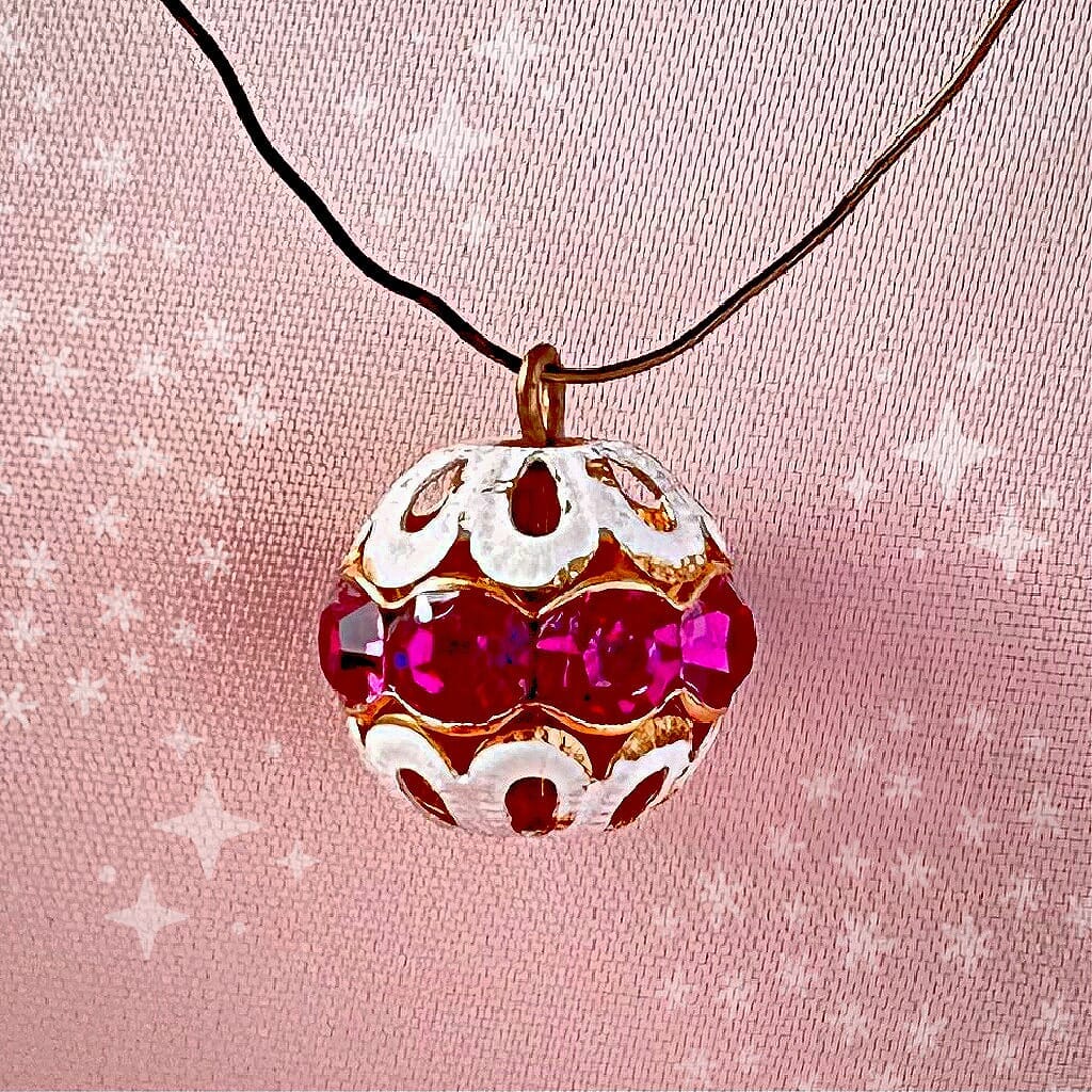 Vintage, fuchsia-coloured, Swarovski rhinestone bead ball  charm on a pink background.