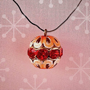 Vintage, hyacinth-coloured, Swarovski rhinestone bead ball  charm on a pink background.