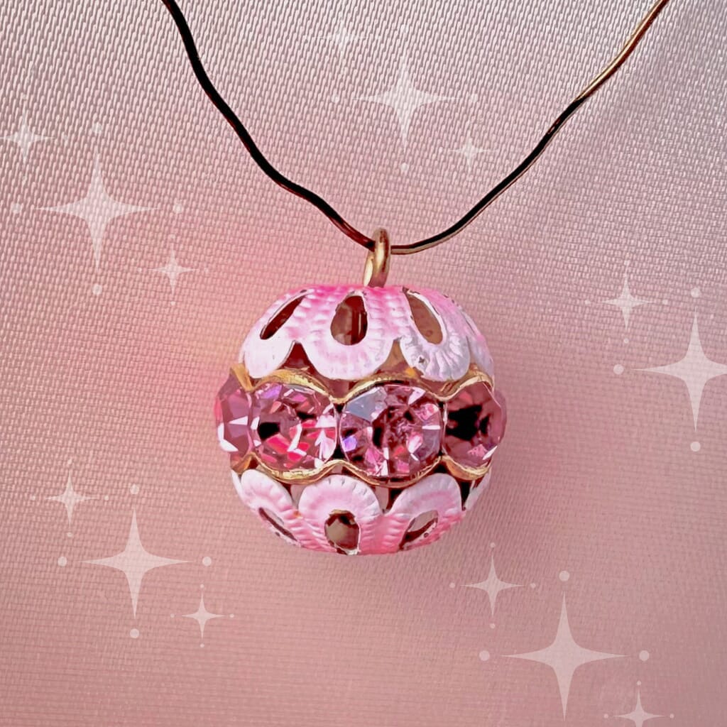 Vintage, rose-coloured, Swarovski rhinestone bead ball  charm on a pink background.