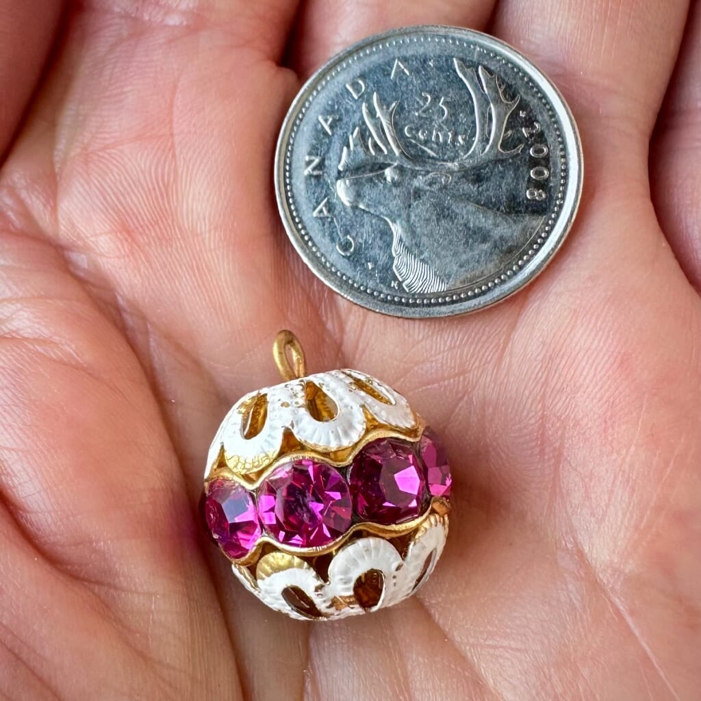 Vintage, fuchsia-coloured, Swarovski rhinestone bead ball  charm on a pink background.