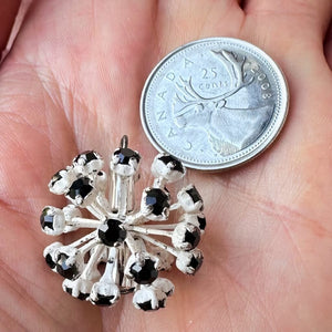 Vintage, jet black-coloured, Swarovski rhinestone, extra large, bead ball next to a Canadian quarter coin on a hand for size comparison.