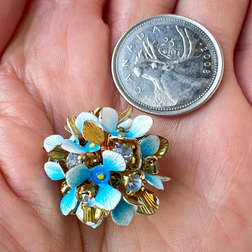 Vintage, Swarovski rhinestone, flower-style, bead ball charm with multi-coloured stones and blue petals, on a pink background.