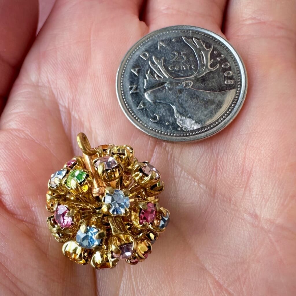 Vintage, Swarovski rhinestone bead ball, multi-coloured stones and gold toned metal, on a pink background.