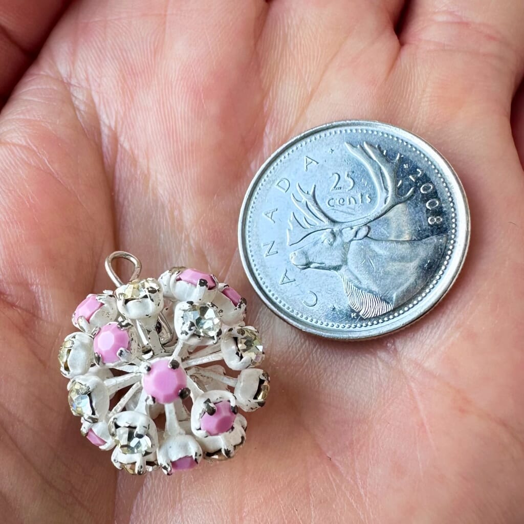 Vintage, Swarovski rhinestone bead ball, pink and crystal-coloured stones and white metal, on a pink background.