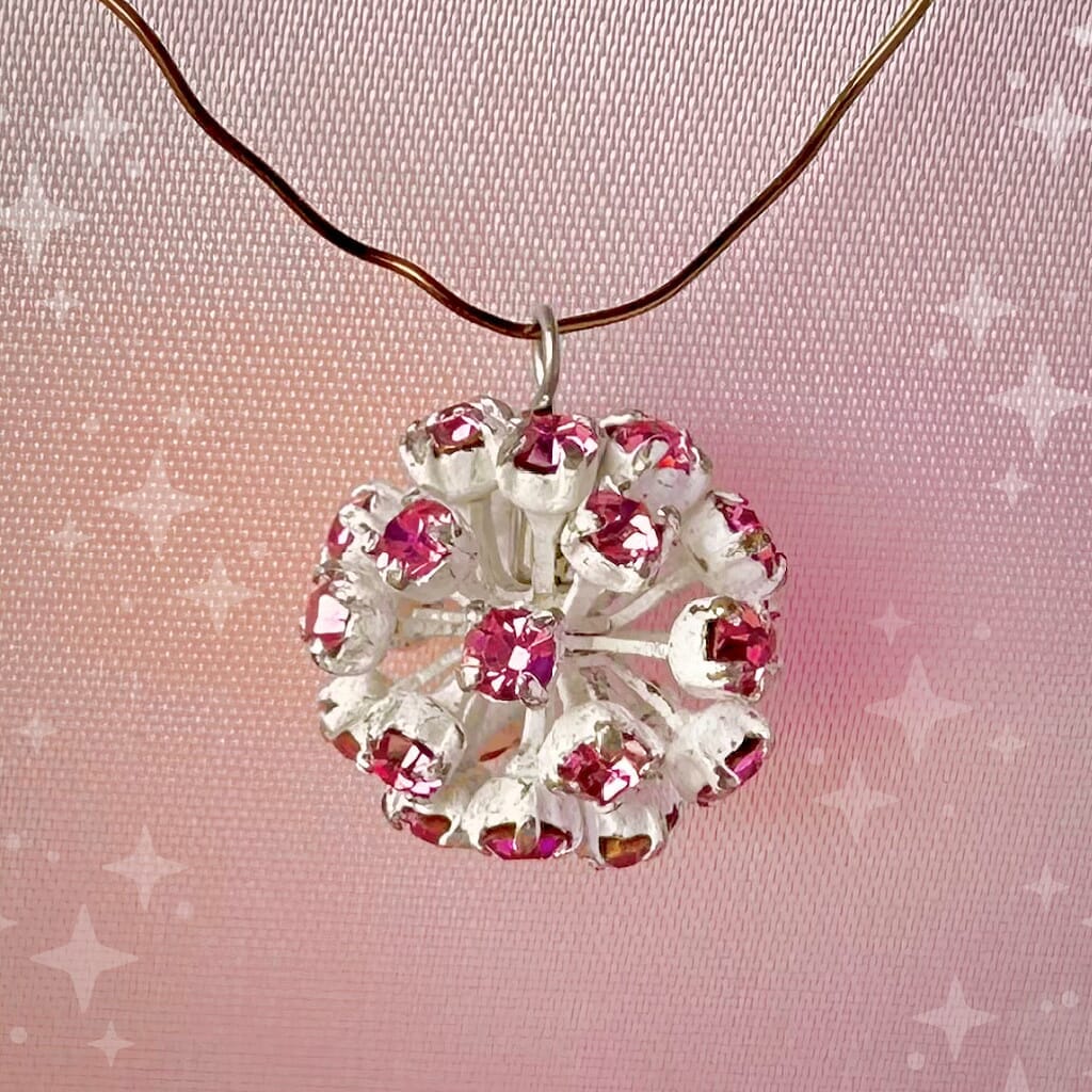 Vintage, Swarovski rhinestone bead ball, rose-coloured stones and white metal, on a pink background.