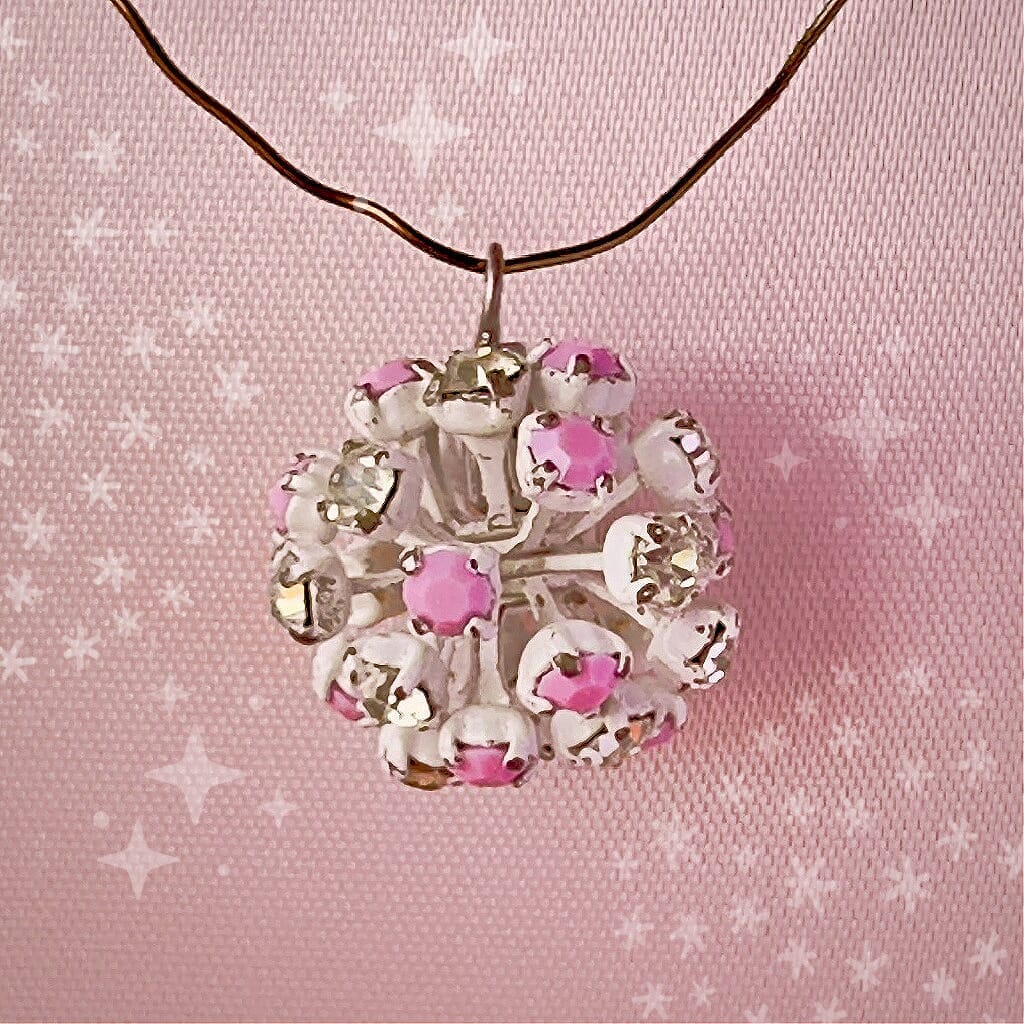 Vintage, Swarovski rhinestone bead ball, pink and crystal-coloured stones and white metal, on a pink background.