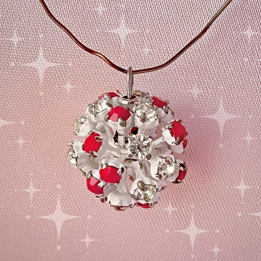 Vintage, Swarovski rhinestone bead ball, opaque red and crystal-coloured stones, and white metal, on a pink background.