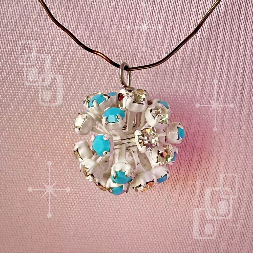 Vintage, Swarovski rhinestone bead ball, opaque turquoise and crystal-coloured stones and white metal, on a pink background.