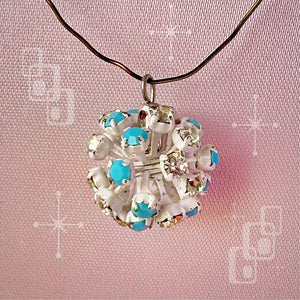 Vintage, Swarovski rhinestone bead ball, opaque turquoise and crystal-coloured stones and white metal, on a pink background.