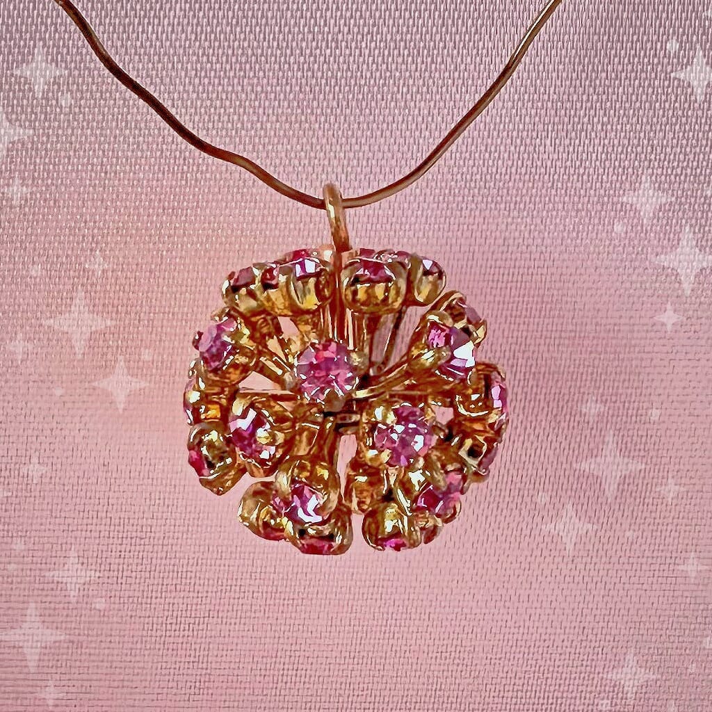 Vintage, Swarovski rhinestone bead ball, rose-coloured stones and gold toned metal, on a pink background.