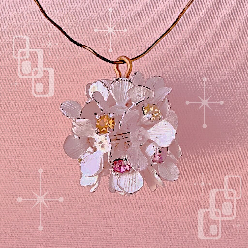 Vintage, Swarovski rhinestone, flower-style bead ball charm, with multi-coloured stones and blue petals, on a pink background.