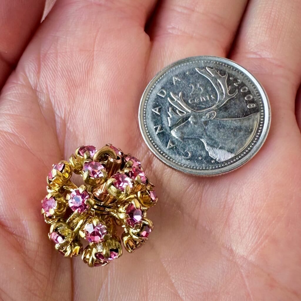 Vintage, Swarovski rhinestone bead ball, rose-coloured stones and gold toned metal, on a pink background.