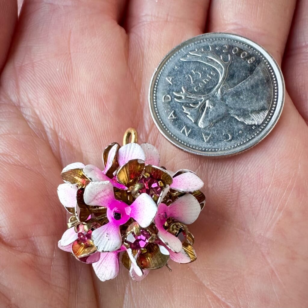 Vintage, Swarovski rhinestone, flower-style, bead ball charm with fuchsia-coloured stones and pink/white flower petals, on a pink background.
