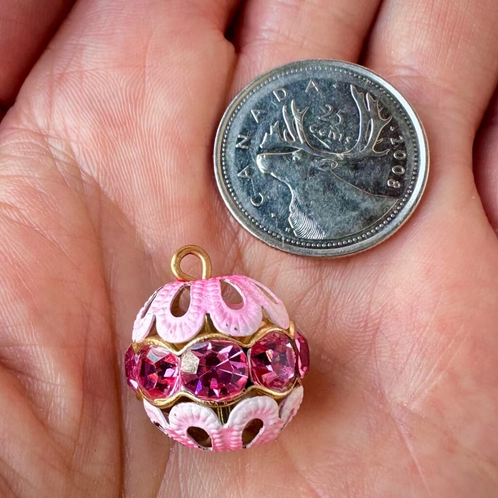 Vintage, rose-coloured, Swarovski rhinestone bead ball  charm on a pink background.